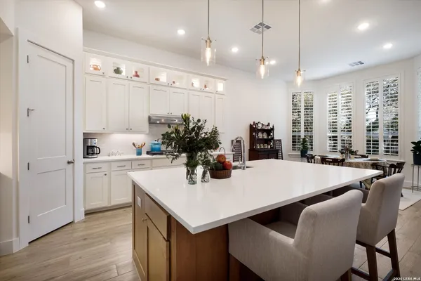 a kitchen with a table chairs sink and cabinets