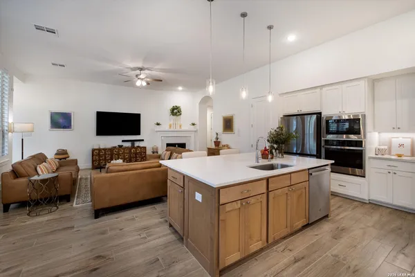 a kitchen with kitchen island granite countertop a sink appliances and cabinets