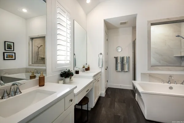 a bathroom with a double vanity sink a mirror and a bathtub