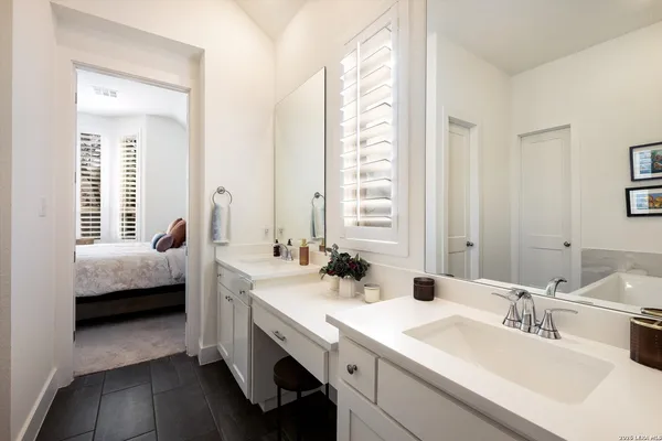 a en suite bathroom with double vanity and a mirror