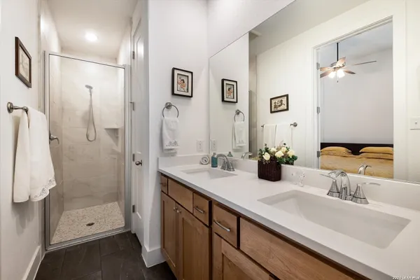 a bathroom with a double vanity sink mirror and shower