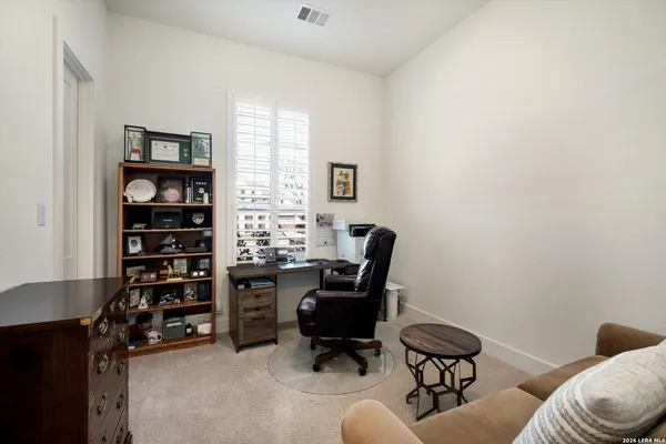 a view of a workspace with furniture and a window