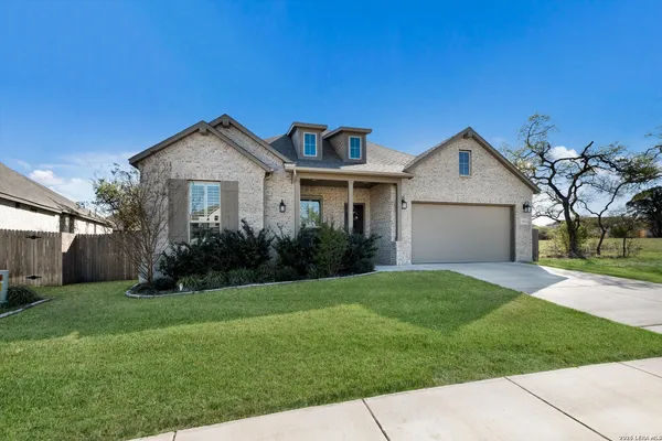 a view of a house with a big yard plants and large trees