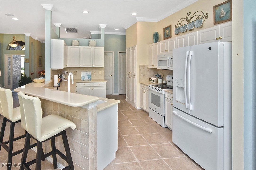 11131 Wine Palm Road Fort Myers, FL 33966 - Photo 14 of 48 a kitchen with stainless steel appliances granite countertop a refrigerator a sink and white cabinets