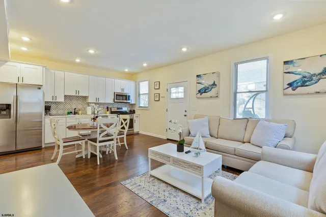a living room kitchen with furniture and kitchen view with wooden floor