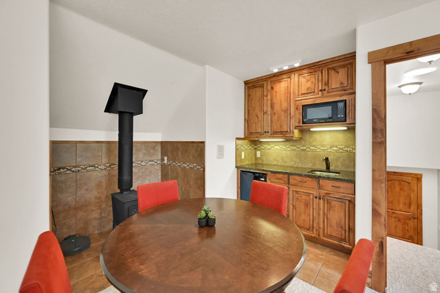 13658 South Fort Street Draper, UT 84020 - Photo 33 of 87 Compact kitchen featuring wood cabinetry, a built-in microwave, a black sink, and granite countertops