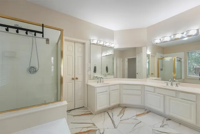 a spacious bathroom with a shower sink vanity and mirror