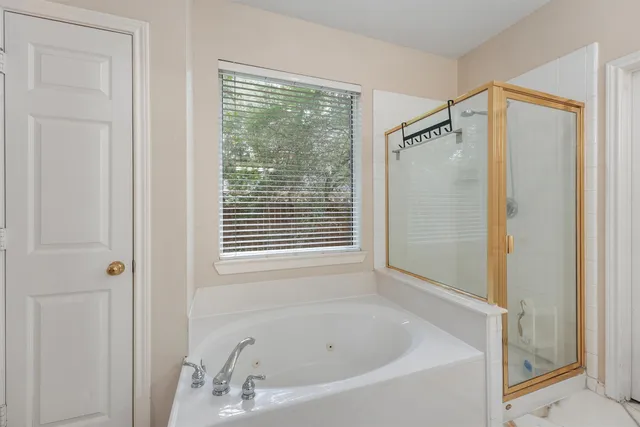 a white bath tub sitting next to a shower