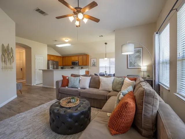 a kitchen with stainless steel appliances granite countertop a stove top oven a sink a dining table and chairs with wooden floor