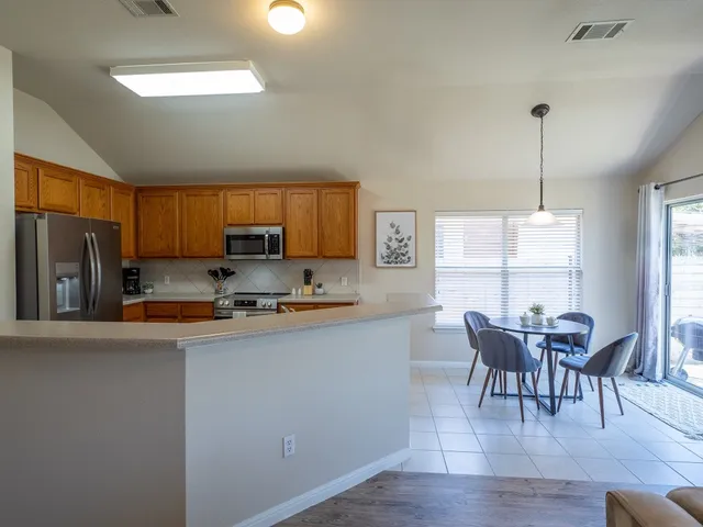 a living room with furniture kitchen and a large window