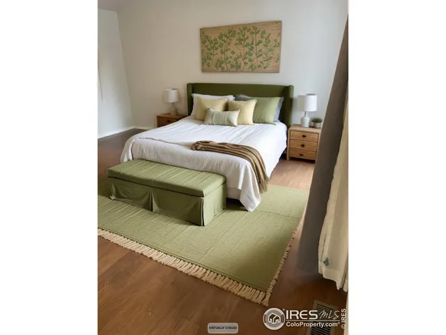 a bedroom with a bed and a wall painting