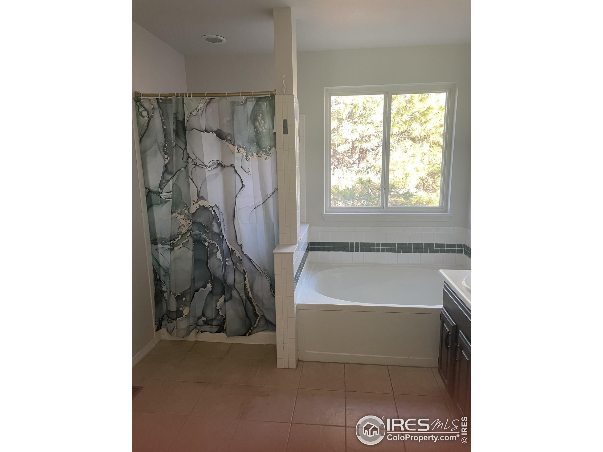 613 Rider Ridge Drive Longmont, CO 80504 - Photo 21 of 34 a bathroom with a bathtub and a shower