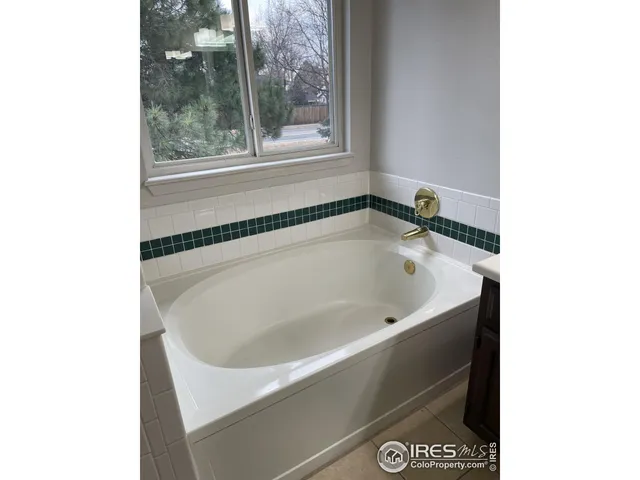 a white bath tub sitting in a bathroom next to a window