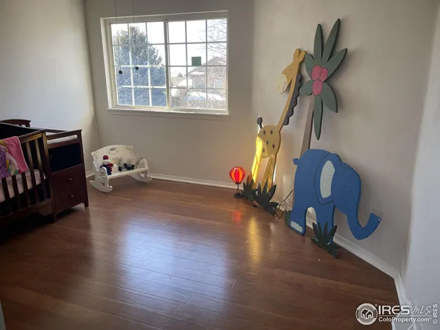 a hallway with wooden floor stairs and a chandelier