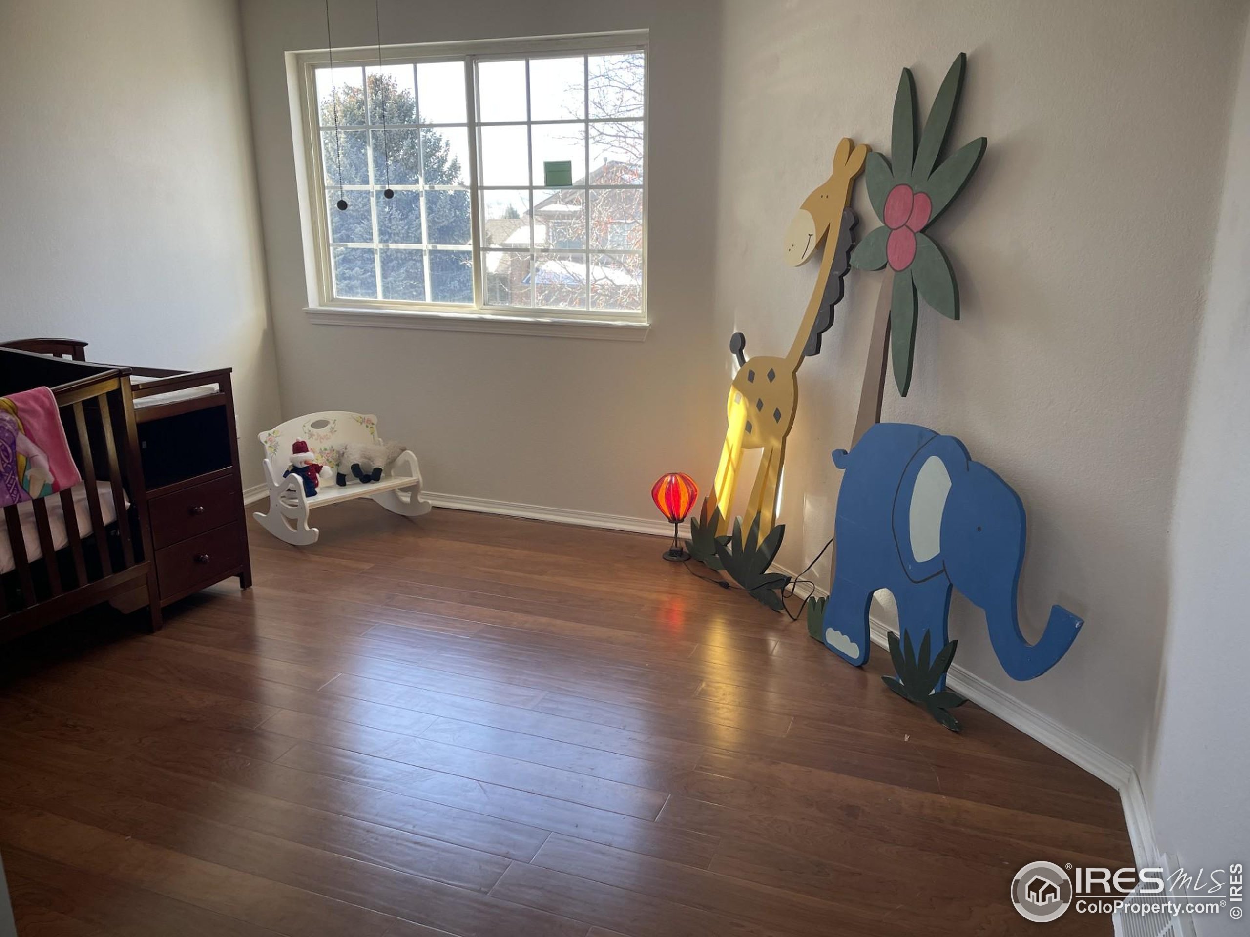 613 Rider Ridge Drive Longmont, CO 80504 - Photo 25 of 34 a hallway with wooden floor stairs and a chandelier