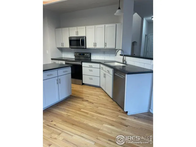 a kitchen with stainless steel appliances granite countertop a sink and a stove