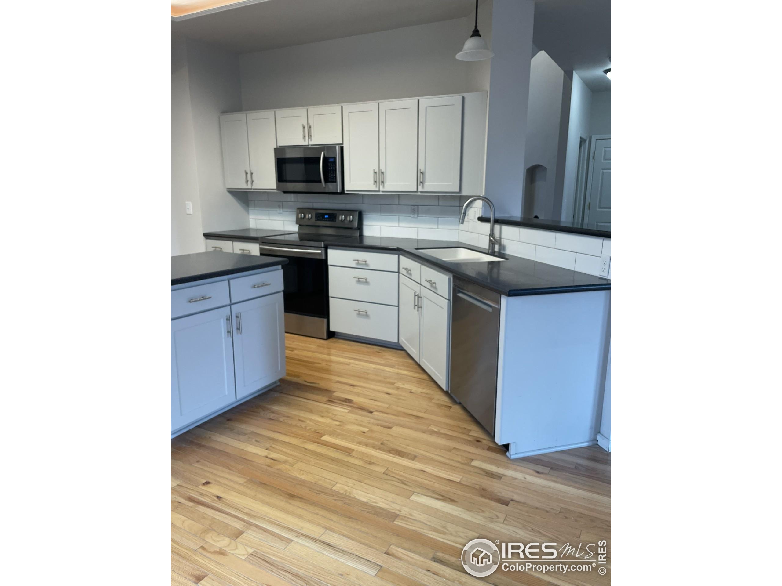 613 Rider Ridge Drive Longmont, CO 80504 - Photo 9 of 34 a kitchen with stainless steel appliances granite countertop a sink and a stove