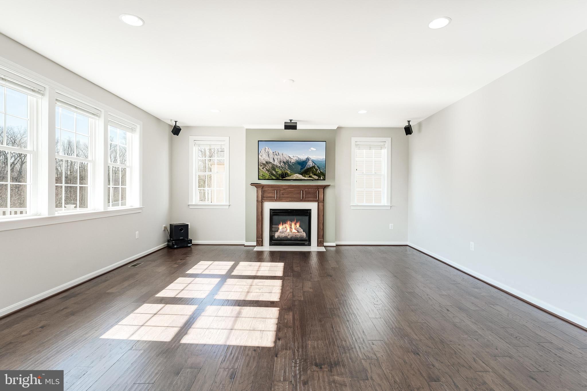 18747 Pier Trail Drive Triangle, VA 22172 - Photo 27 of 84 an empty room with windows a fireplace and wooden floor