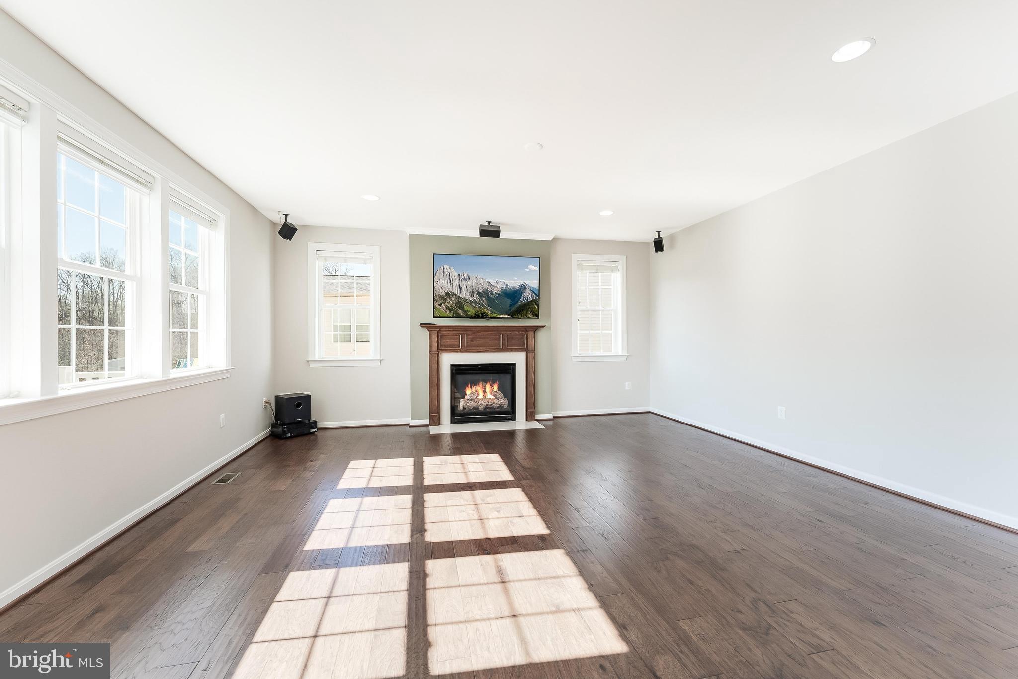 18747 Pier Trail Drive Triangle, VA 22172 - Photo 28 of 84 an empty room with wooden floor a fireplace and windows