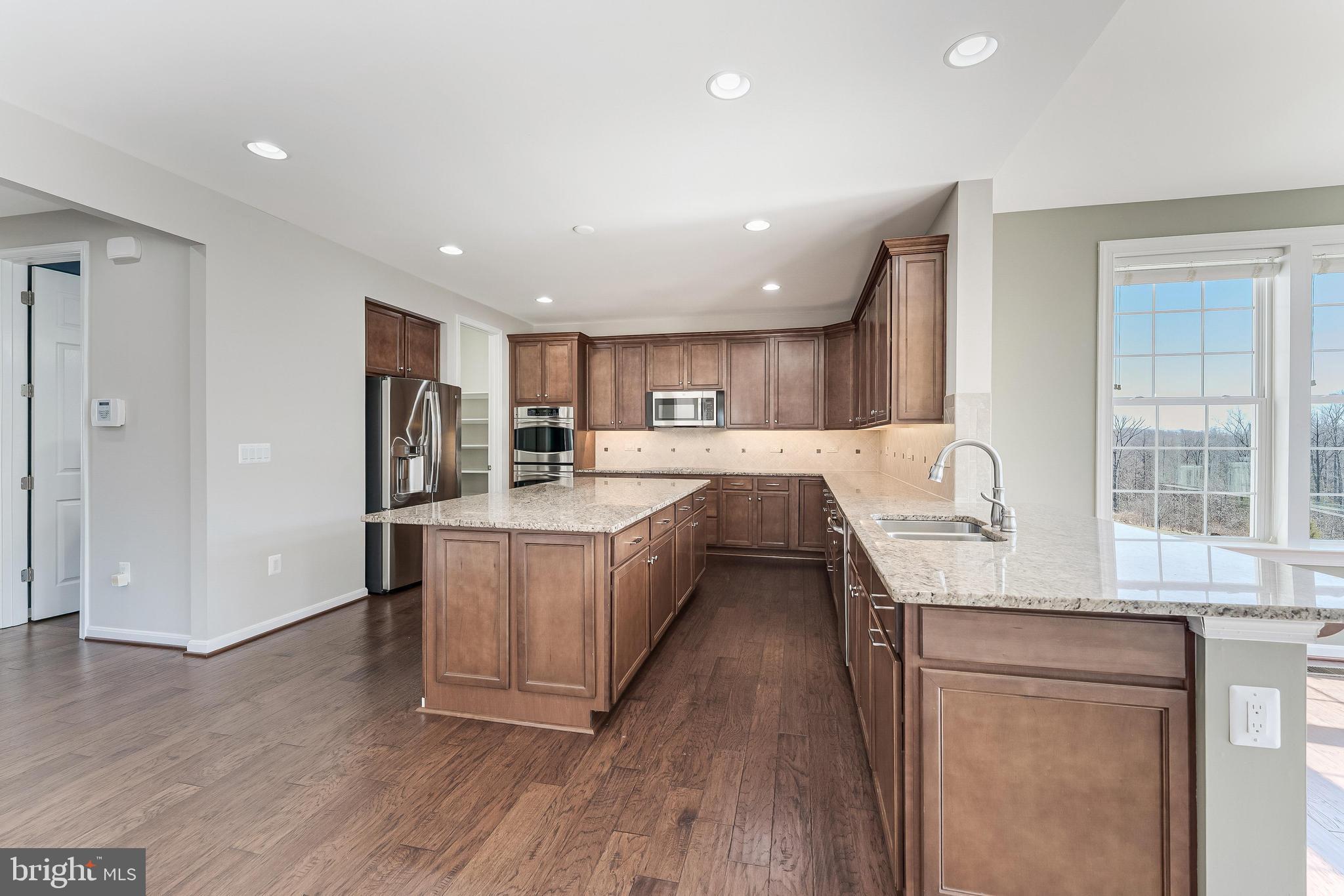 18747 Pier Trail Drive Triangle, VA 22172 - Photo 37 of 84 a large kitchen with stainless steel appliances granite countertop a lot of counter space and wooden floors