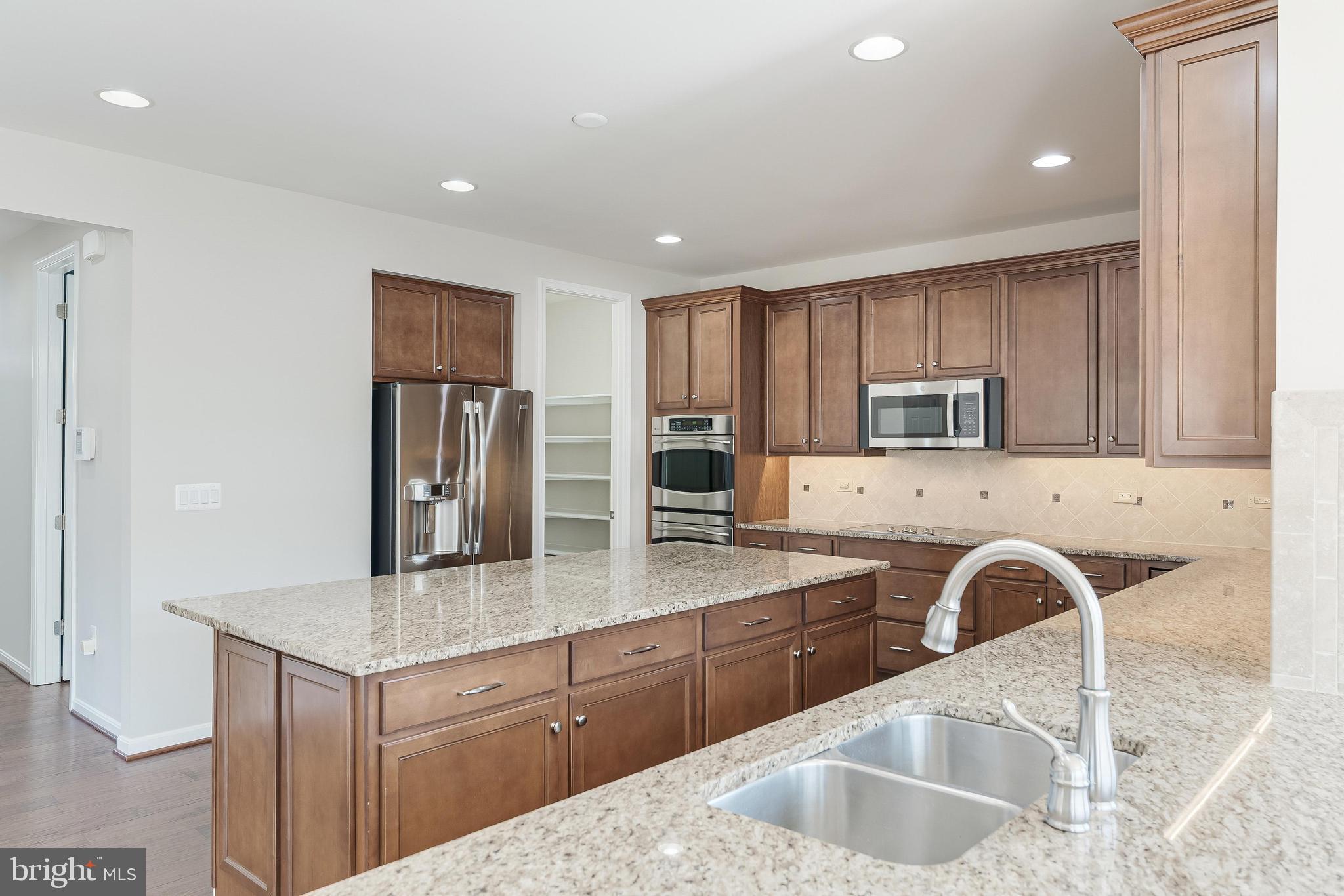 18747 Pier Trail Drive Triangle, VA 22172 - Photo 40 of 84 a kitchen with stainless steel appliances granite countertop a sink a stove and a refrigerator