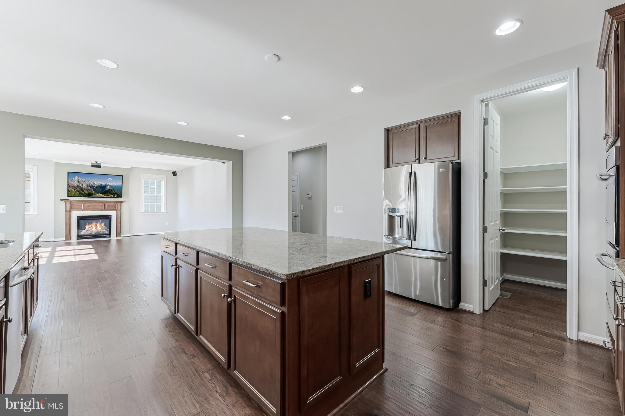 18747 Pier Trail Drive Triangle, VA 22172 - Photo 41 of 84 a kitchen with stainless steel appliances a kitchen island wooden floors and wooden cabinets