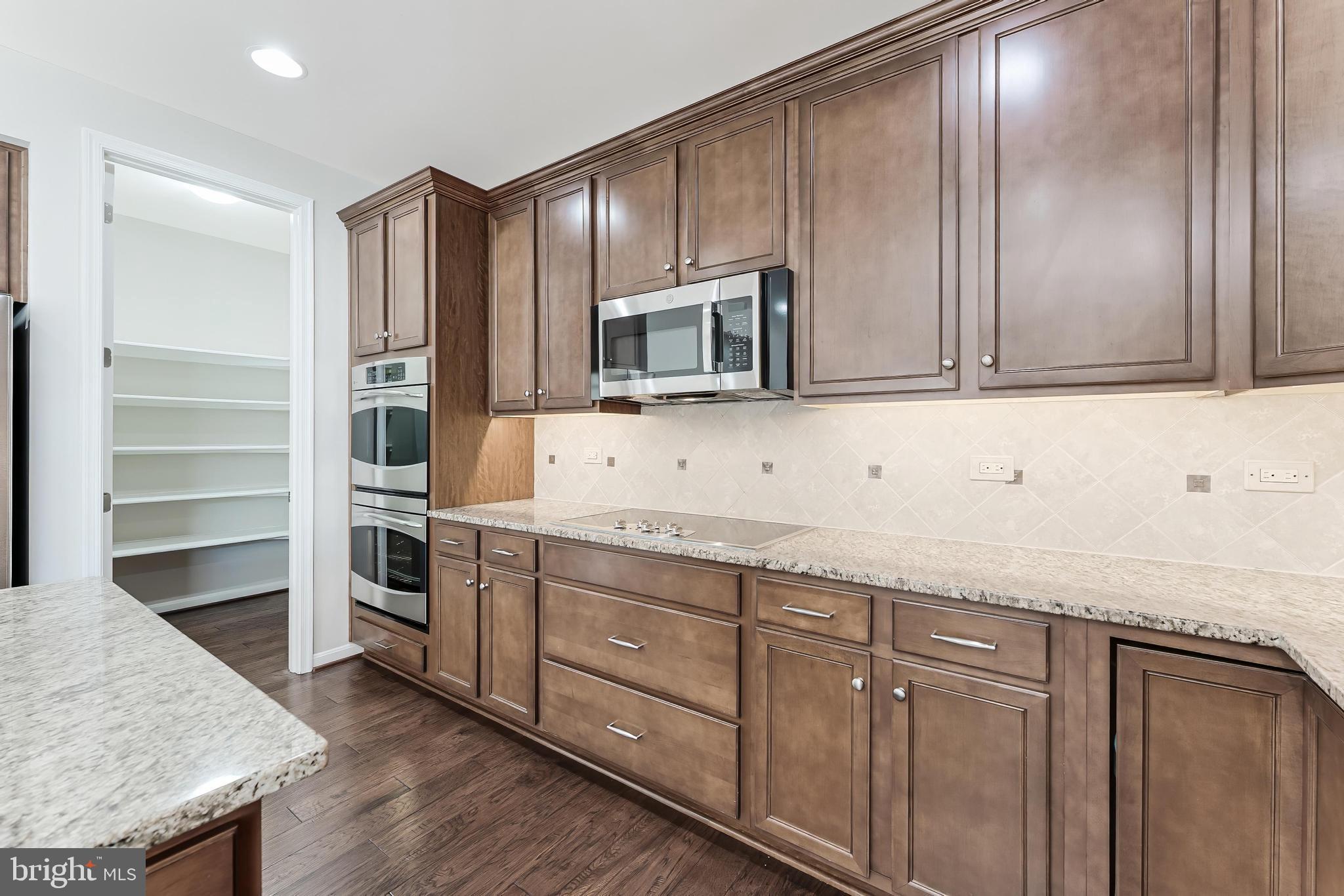18747 Pier Trail Drive Triangle, VA 22172 - Photo 43 of 84 a kitchen with stainless steel appliances granite countertop a stove a microwave and a refrigerator