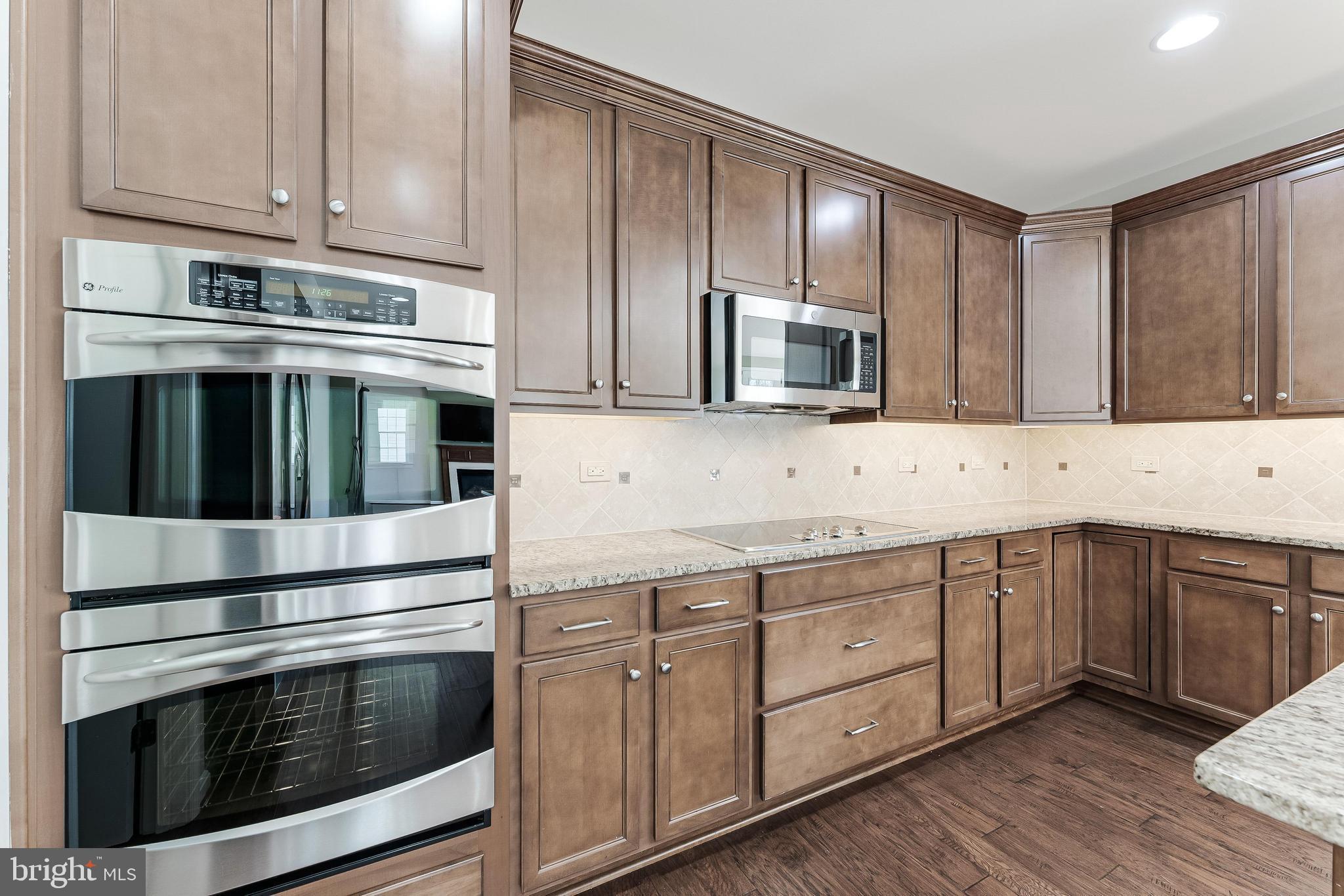 18747 Pier Trail Drive Triangle, VA 22172 - Photo 44 of 84 a kitchen with granite countertop stainless steel appliances and wooden cabinets