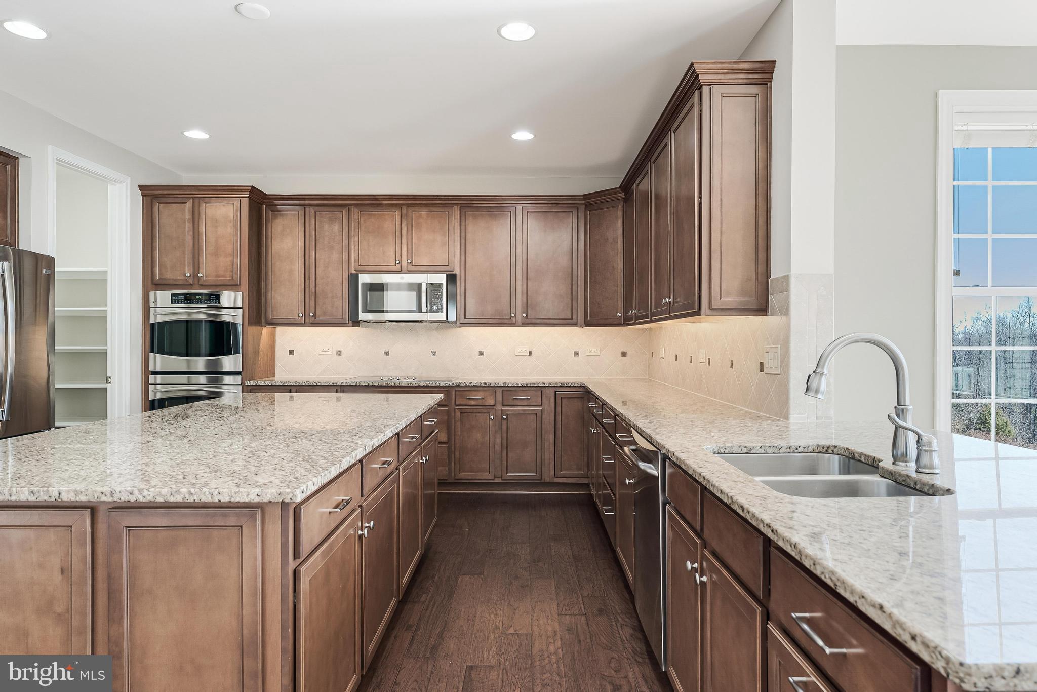 18747 Pier Trail Drive Triangle, VA 22172 - Photo 45 of 84 a kitchen with stainless steel appliances granite countertop a sink stove and refrigerator