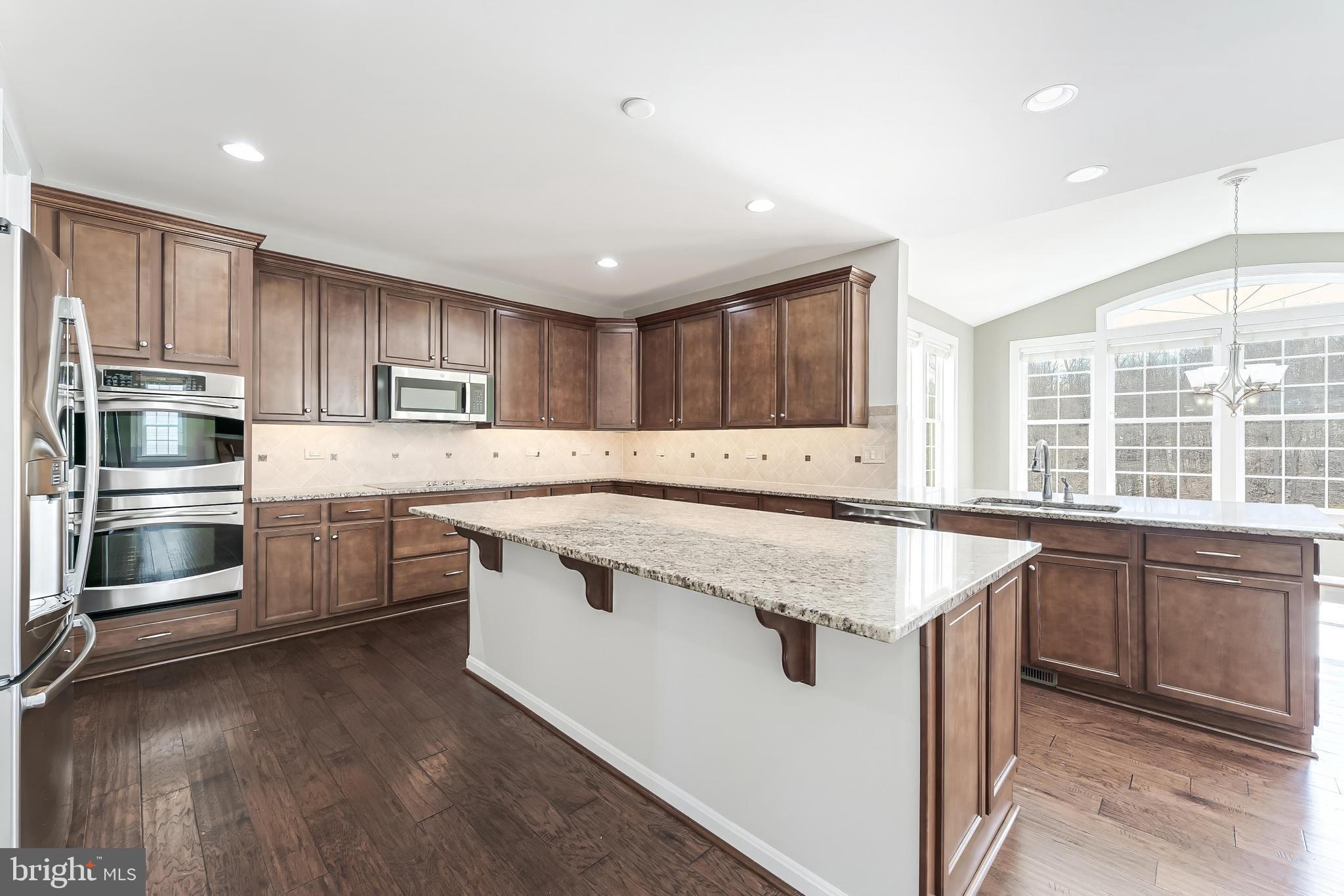 18747 Pier Trail Drive Triangle, VA 22172 - Photo 46 of 84 a kitchen with stainless steel appliances granite countertop a stove a sink and a refrigerator
