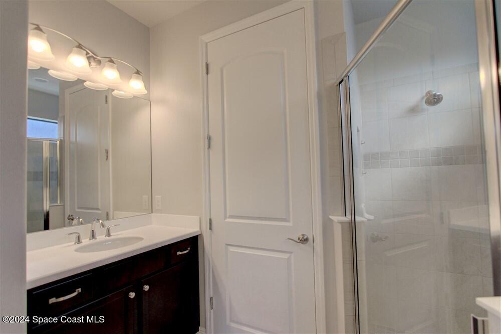 3267 Addison Drive Melbourne, FL 32940 - Photo 27 of 37 a bathroom with a double vanity sink a and mirror