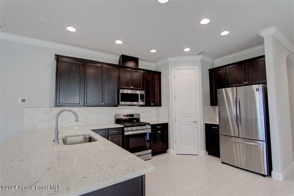 3267 Addison Drive Melbourne, FL 32940 - Photo 30 of 37 a kitchen with stainless steel appliances a refrigerator sink microwave and cabinets