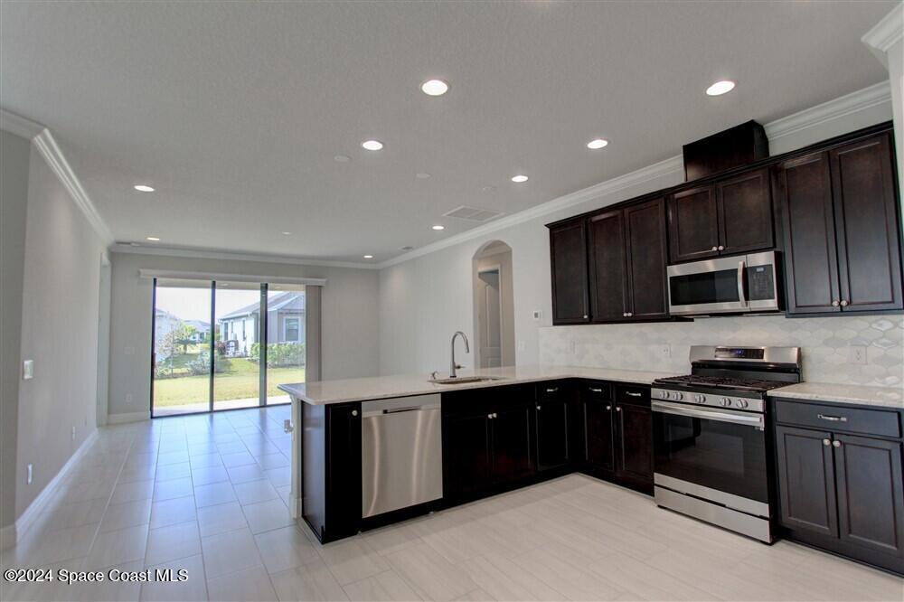 3267 Addison Drive Melbourne, FL 32940 - Photo 31 of 37 a kitchen with stainless steel appliances granite countertop a stove a sink and a microwave