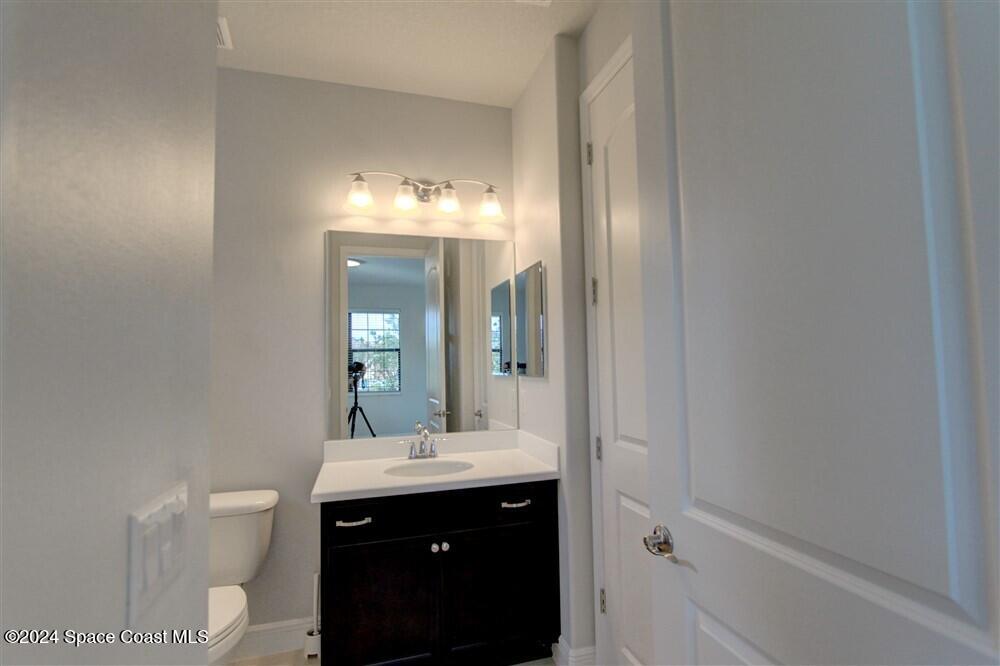 3267 Addison Drive Melbourne, FL 32940 - Photo 6 of 37 a bathroom with a toilet sink and mirror
