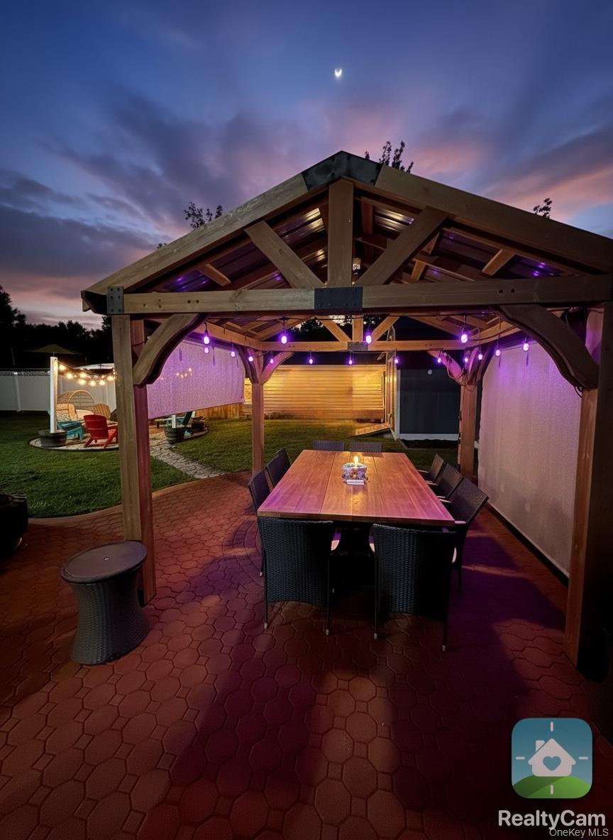 30 Classon Avenue Mastic, NY 11950 - Photo 20 of 21 Patio terrace at dusk featuring outdoor dining area, a fenced backyard, and a patio
