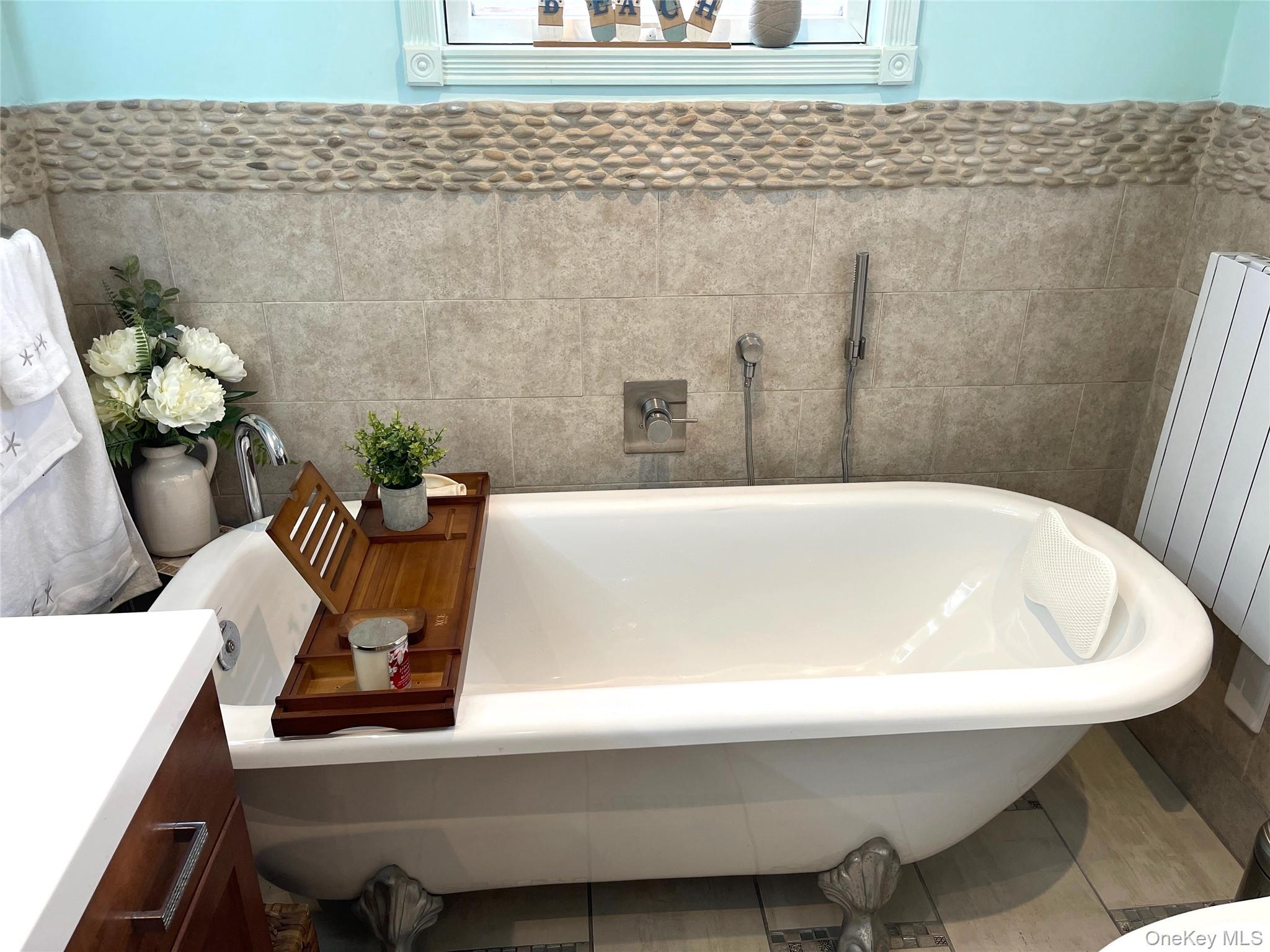 30 Classon Avenue Mastic, NY 11950 - Photo 8 of 21 Bathroom featuring tile walls, wainscoting, vanity, a freestanding bath, and radiator