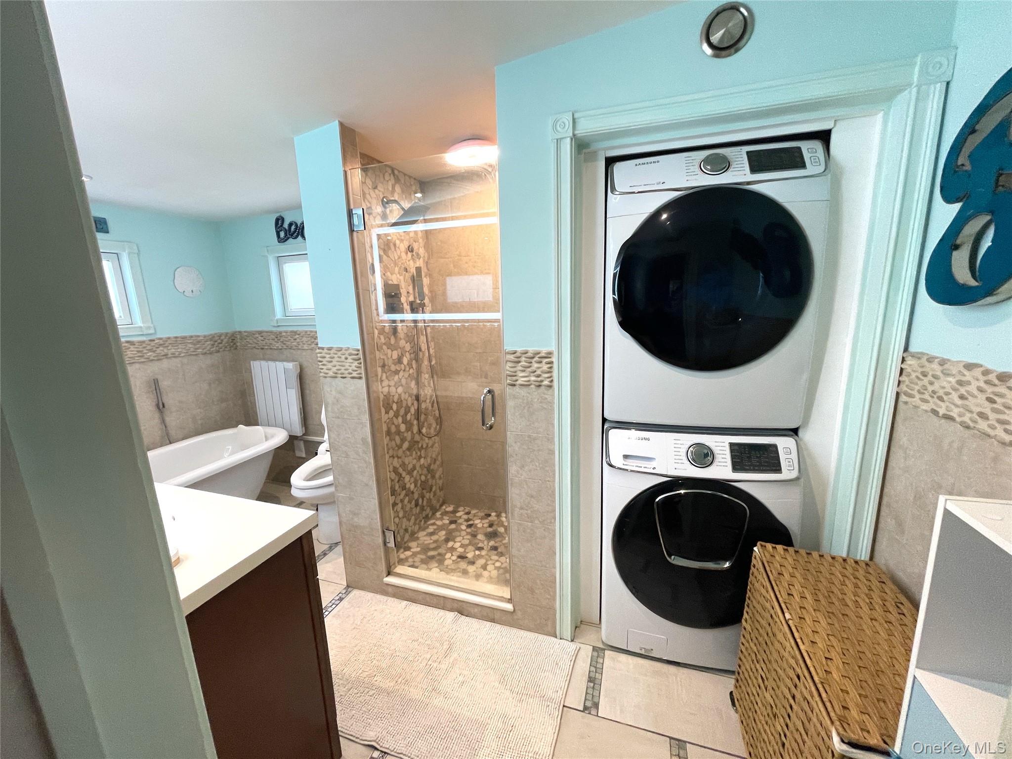 30 Classon Avenue Mastic, NY 11950 - Photo 9 of 21 Washroom featuring tile walls, stacked washer / drying machine, wainscoting, and light tile patterned floors
