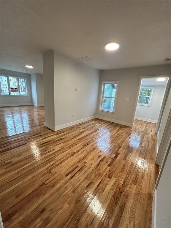 121 Horton Street, Unit 2 Fall River, MA 02723 - Photo 4 of 7 an empty room with wooden floor and windows