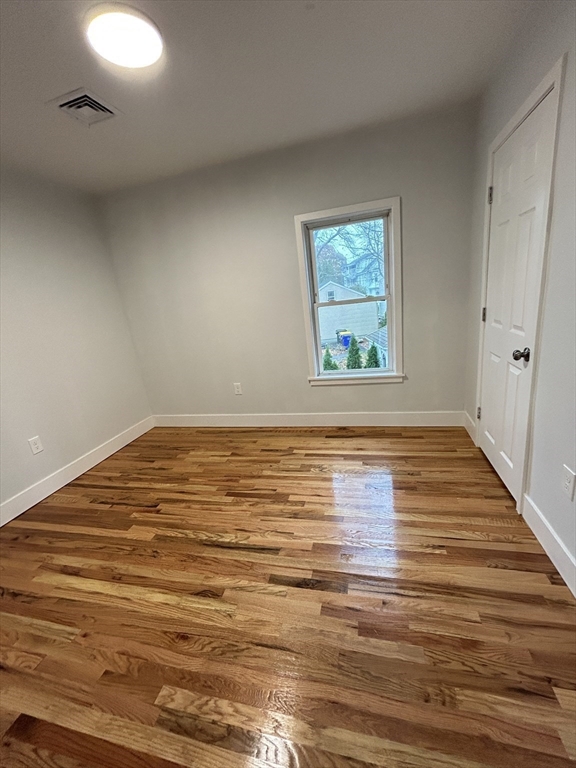 121 Horton Street, Unit 2 Fall River, MA 02723 - Photo 6 of 7 a view of an empty room with wooden floor and a window