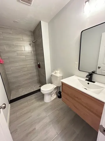 a bathroom with a sink a toilet and shower