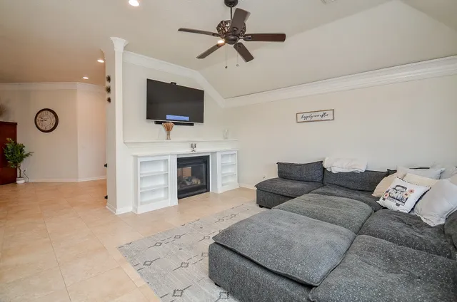 a living room with furniture kitchen view and large windows