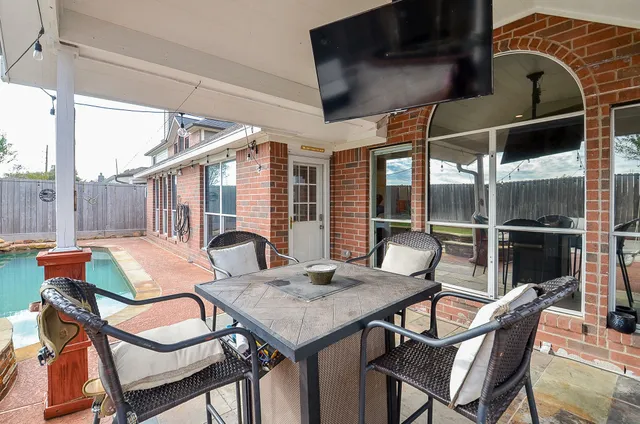 a view of a patio with table and chairs with wooden fence