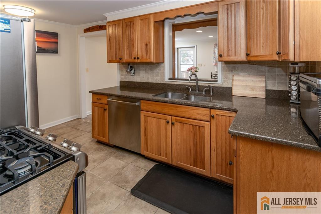 429 Edgeworth Street Middlesex, NJ 08846 - Photo 6 of 23 a kitchen with wooden cabinets and a stove top oven