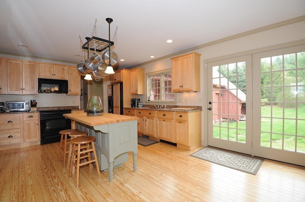 265 Leverett Road Amherst, MA 01002 - Photo 6 of 30 a large kitchen with kitchen island granite countertop a stove a sink a center island and windows
