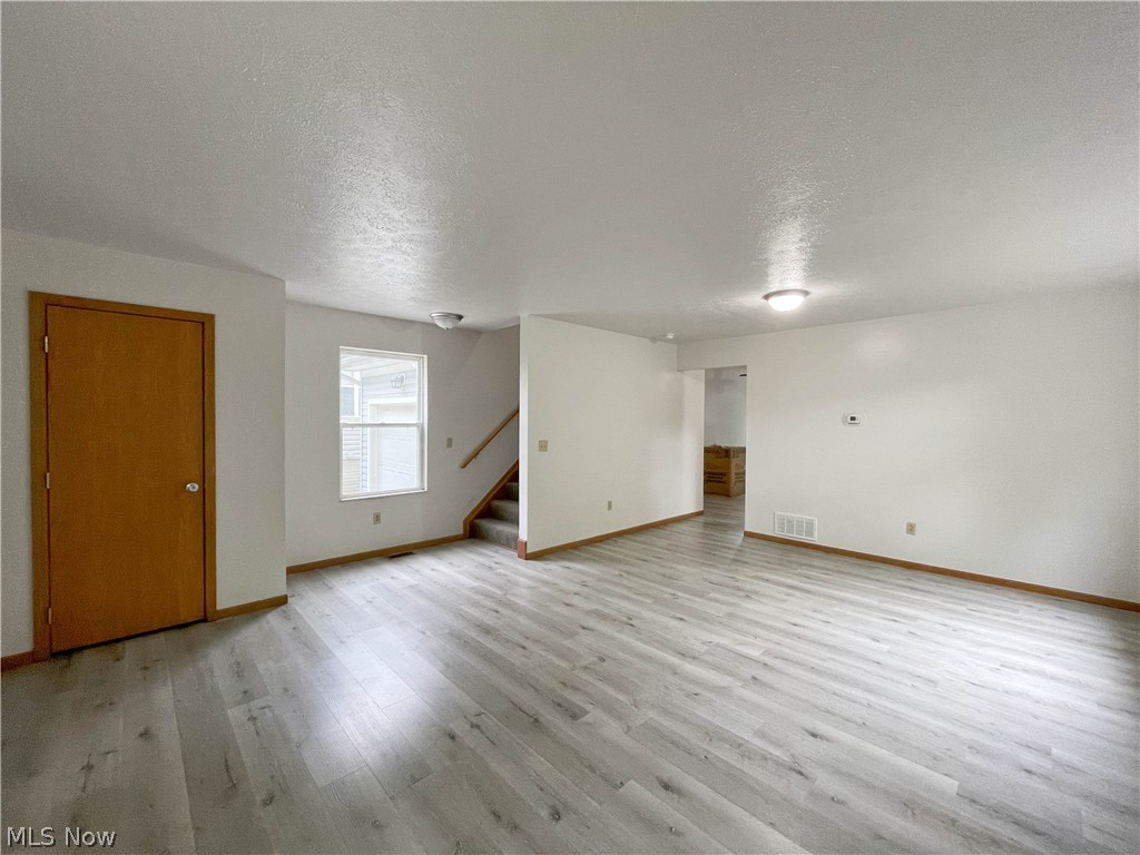 263 Reed Avenue Campbell, OH 44405 - Photo 6 of 30 Spare room featuring light hardwood / wood-style floors and a textured ceiling