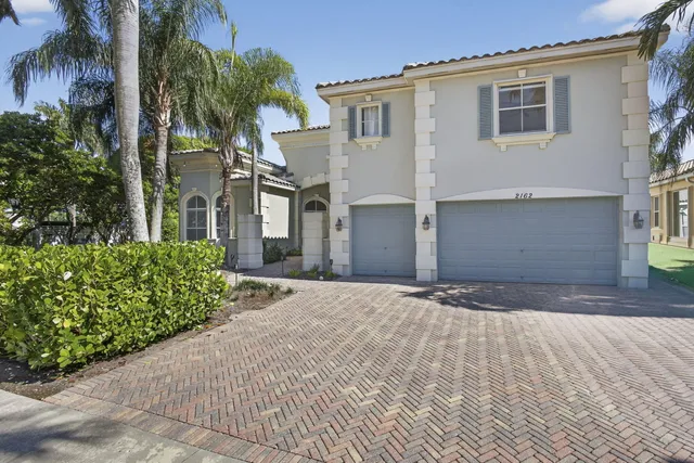 a front view of a house with a yard and a garage