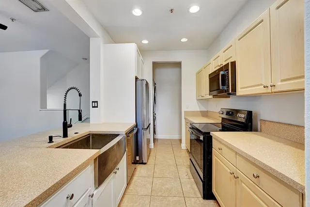 a kitchen that has a sink a stove and refrigerator