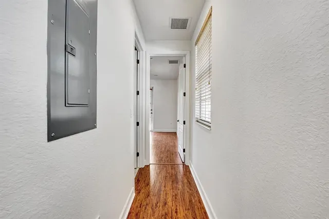 a view of empty room with wooden floor