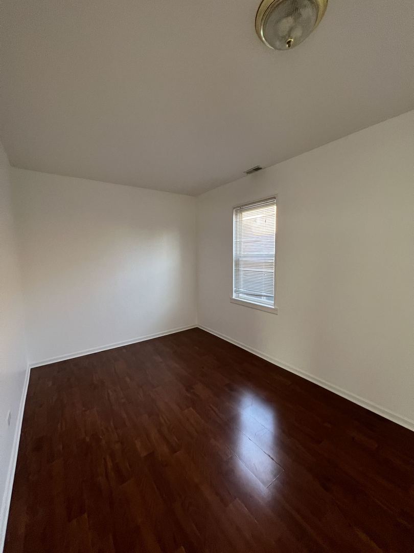 4533 South Richmond Street, Unit 2 Chicago, IL 60632 - Photo 5 of 7 an empty room with wooden floor and windows