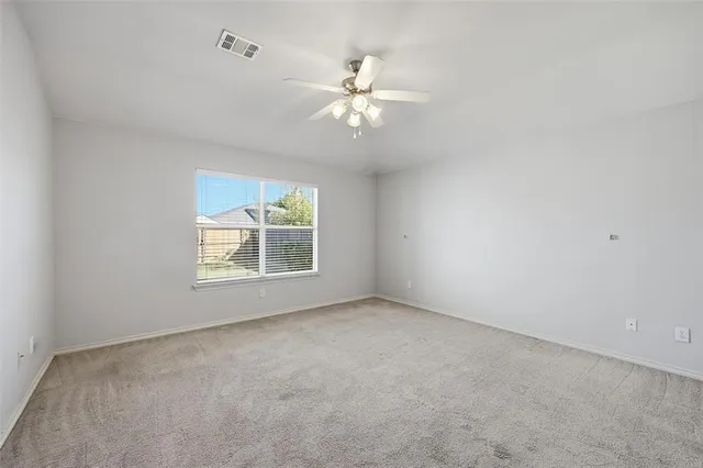 an empty room with a window and a fan